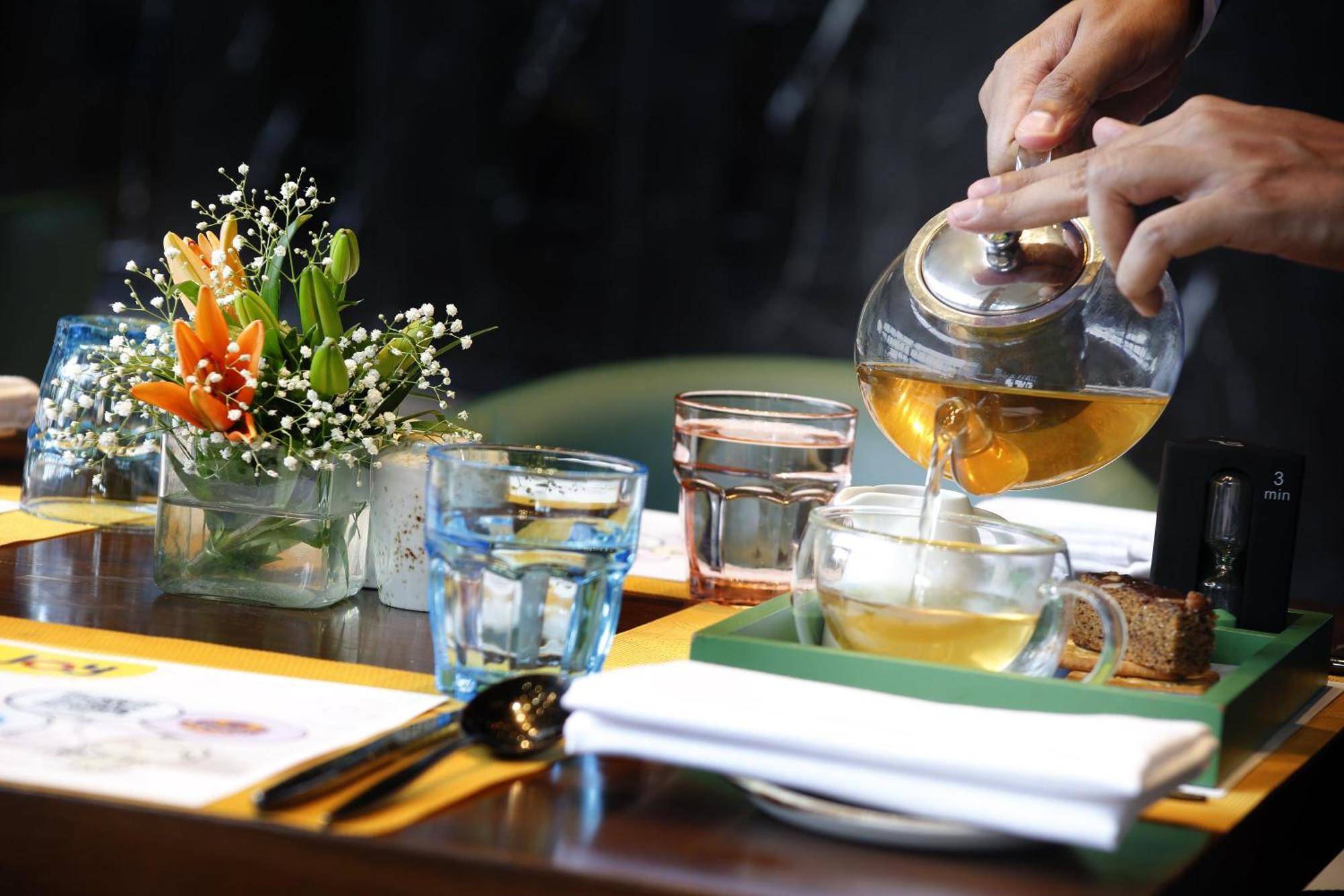Novotel Kolkata Hotel And Residences Kültér fotó A server pours tea at a restaurant